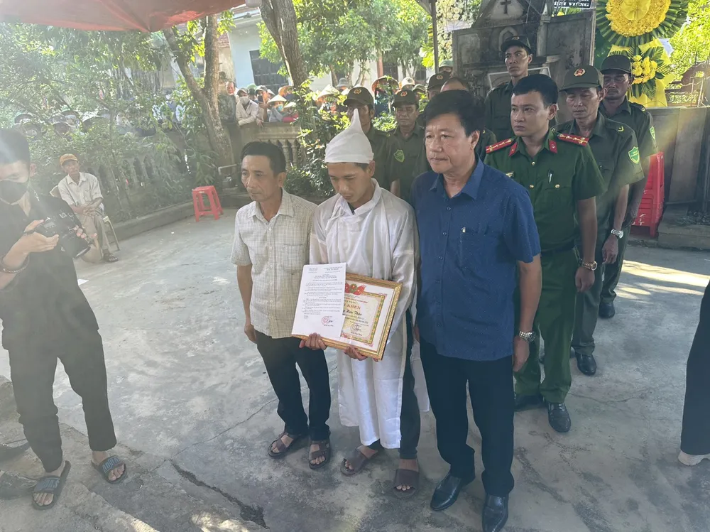 Chính quyền xã Quảng Minh trao quyết định và truy tặng giấy khen cho thân nhân của ông Thão trước sự chứng kiến của rất đông bà con nhân dân. Ảnh: M.T Tặng giấy khen cho người đàn ông tử vong khi chữa cháy rừng