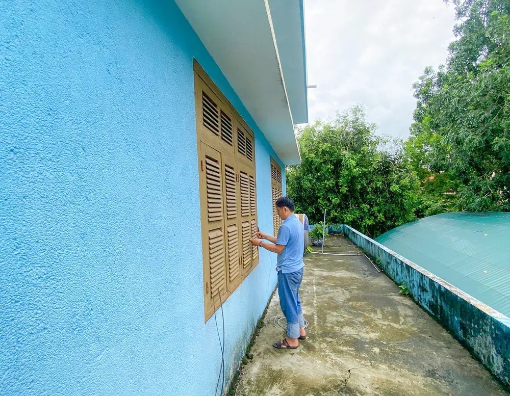 Một số người dân sớm chủ động chằng chống cửa đề phòng bão đổ bộ. Ảnh: B.THIÊN z5842363518627_90387f34efa3177d33199b3113587503.jpg