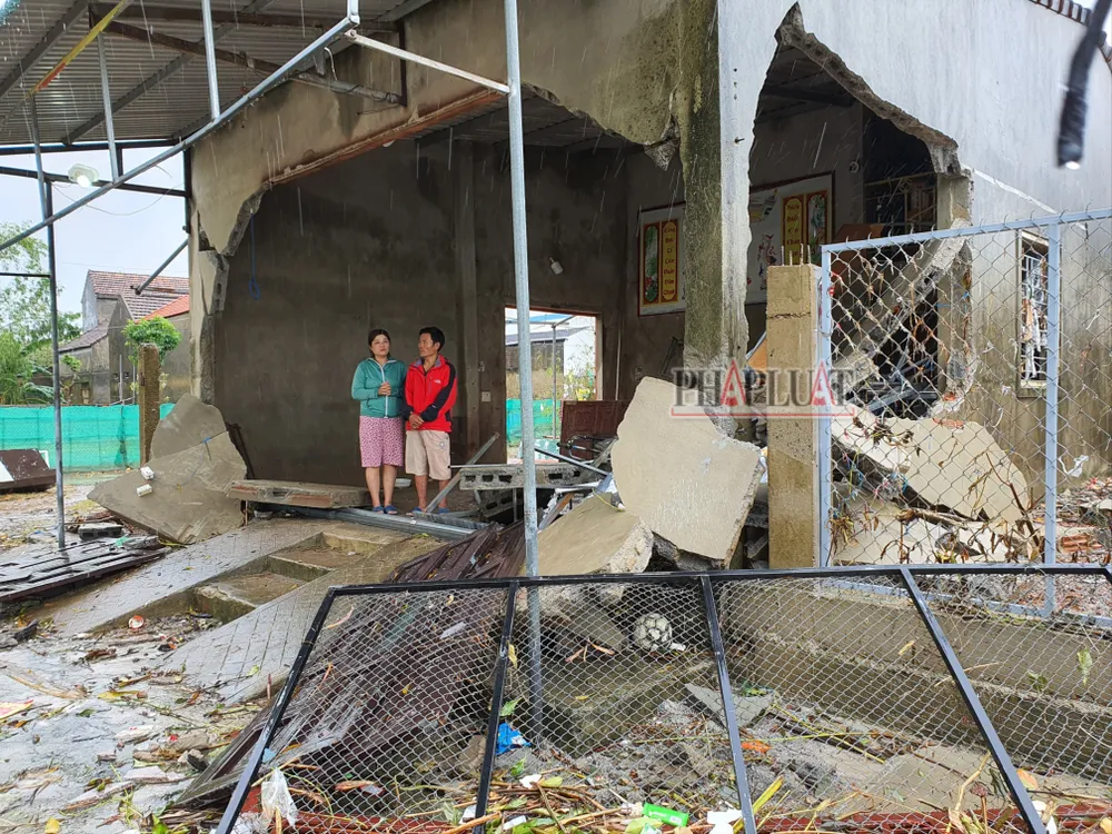 Hai vợ chồng đứng thất thần bên căn nhà bị sóng lũ đánh sập ở Quảng Bình