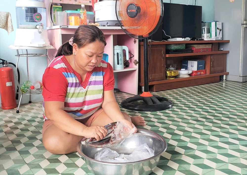 Hàng xóm thường mang cho gia đình chị Xí ít cá biển để bữa cơm không quá đạm bạc. Ảnh: T.AN