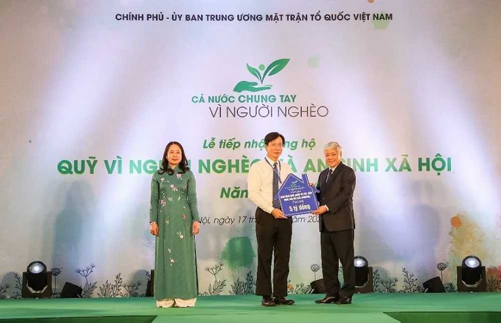Đồng chí Đỗ Văn Chiến - Bí thư trung ương Đảng, Chủ tịch Uỷ ban Trung ương MTTQ Việt Nam nhận biểu trưng kinh phí ủng hộ Quỹ Vì người nghèo và ASXH từ đồng chí Phạm Đức Tuấn – Phó Tổng giám đốc, Chủ tịch công đoàn Agribank.