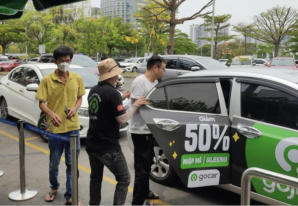 Nhân sự hỗ trợ từ Gojek hướng dẫn hành khách tại điểm đón GoCar ở ga quốc tế đến sân bay Tân Sơn Nhất.