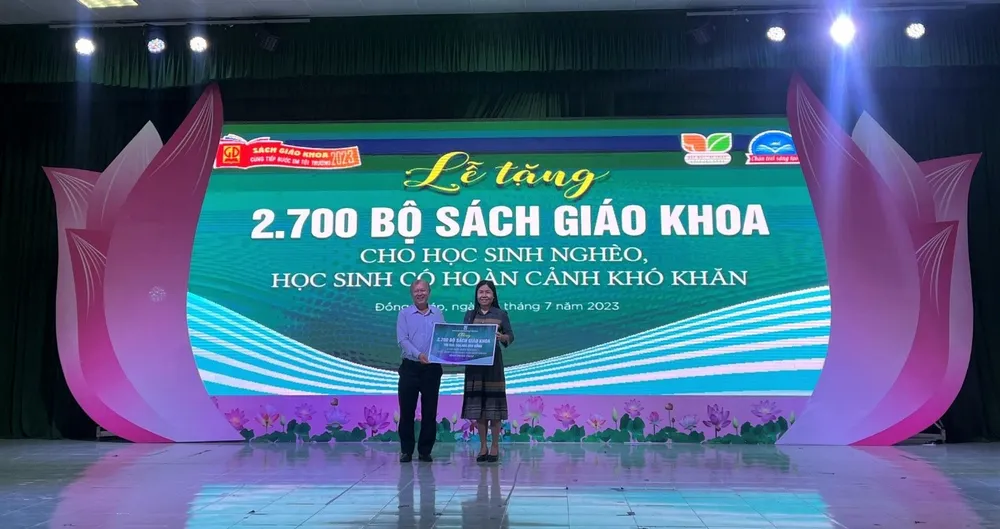 Bà Ngô Thúy Anh – đại diện Sở Giáo dục và Đào tạo tỉnh Đồng Tháp lên nhận bảng tượng trưng 2.700 bộ sách giáo khoa cho học sinh nghèo, có hoàn cảnh khó khăn trên địa bàn tỉnh. sach-giao-khoa-2.jpg