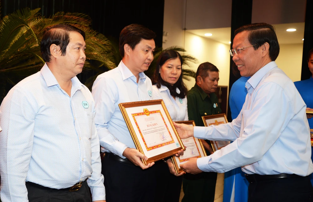 Ông Phan Văn Mãi, Chủ tịch UBND TP.HCM trao bằng khen cho các tổ chức các nhân tiêu biểu trong việc hiến đất mở rộng hẻm. Ảnh: K.C