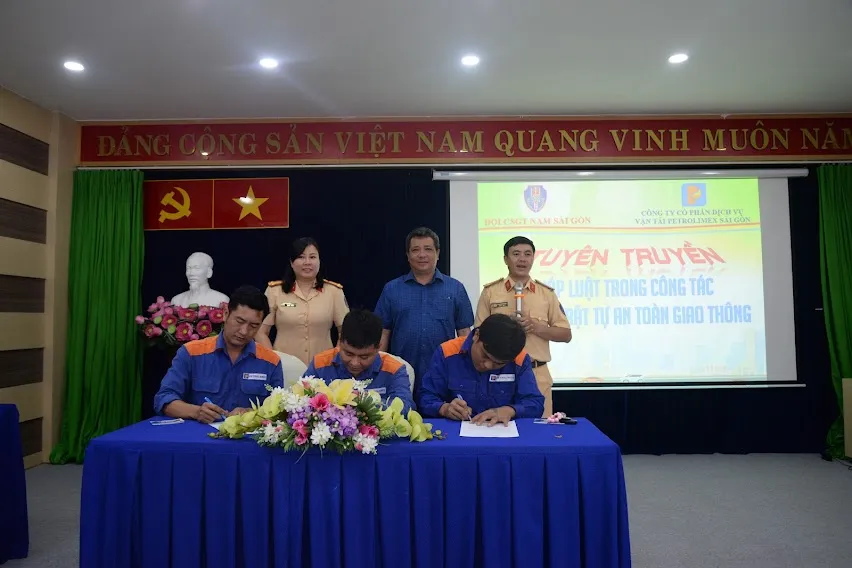 Đại diện Công ty Cổ phần Vận tải và Dịch vụ Petrolimex Sài Gòn và cảnh sát giao thông chứng kiến các tài xế ký cam kết về tuân thủ luật lệ giao thông. Ảnh: H.V HKV_9811.JPG