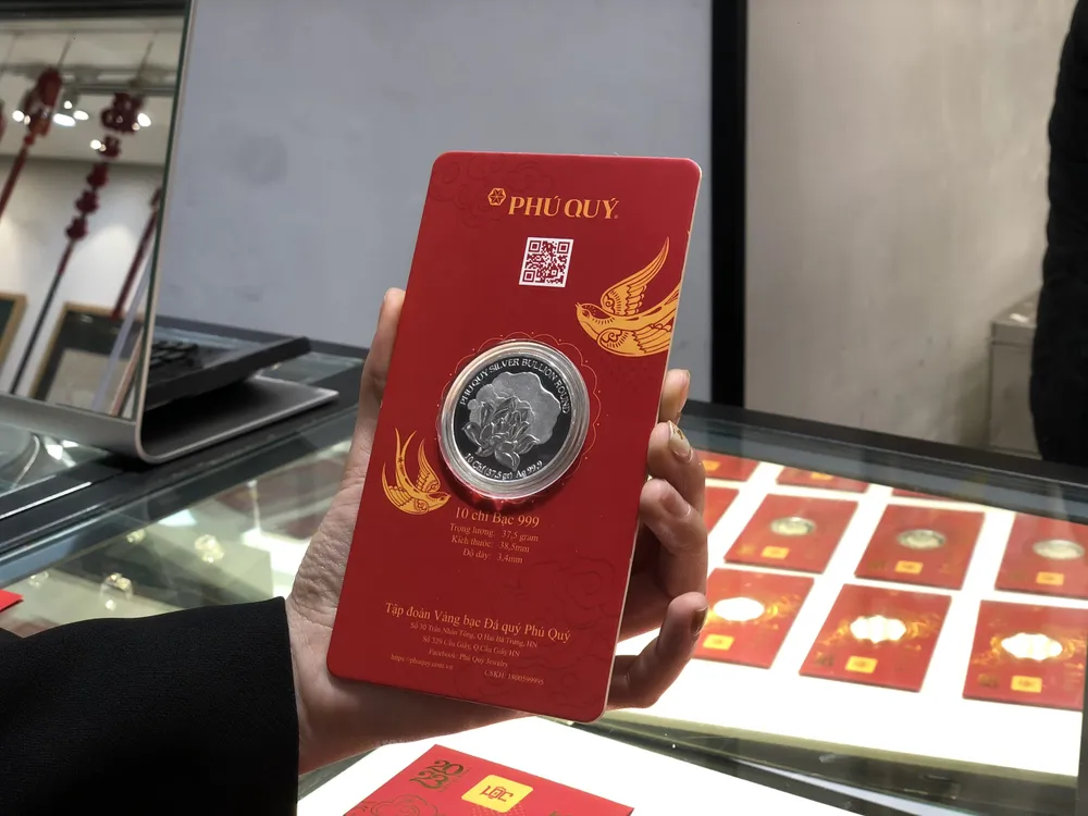 Với nguyên liệu là bạc nguyên chất 999, thiết kế hình tròn dạng đồng xu được dập nổi 3D hai mặt, định lượng 10 chỉ, đồng bạc "Liên hoa Bồ Đề" của Tập đoàn Vàng bạc Đá quý Phú Quý đã thu hút người mua. Ảnh: Minh Trúc. Với nguyên liệu là bạc nguyên chất 999, thiết kế hình tròn dạng đồng xu được dập nổi 3D hai mặt, định lượng 10 chỉ, đồng bạc "Liên hoa Bồ Đề" của Tập đoàn Vàng bạc Đá quý Phú Quý đã thu hút người mua. Ảnh: Minh Trúc.