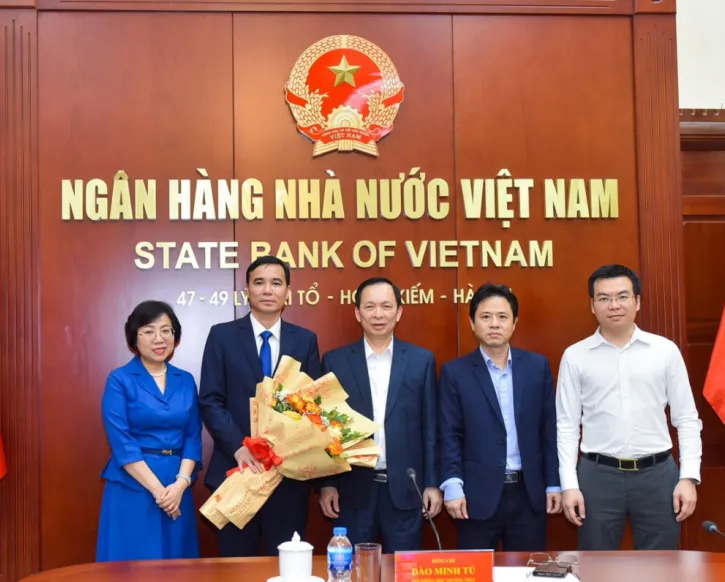 Phó Thống đốc thường trực NHNN Đào Minh Tú (đứng giữa), Tổng Biên tập Hoàng Thanh Nhàn (ngoài cùng bên trái) và lãnh đạo Vụ Tổ chức cán bộ NHNN chúc mừng Phó Tổng Biên tập Trần Trung Thượng. Ảnh: SBV