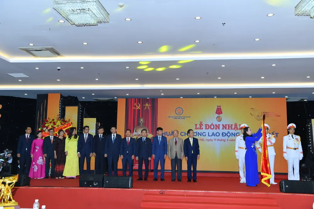Phó Chủ tịch nước Võ Thị Ánh Xuân gắn Huân chương lên cờ thi đua. Ảnh: MINH TRÚC Hiệp hội doanh nghiệp nhỏ và vừa 1.JPG