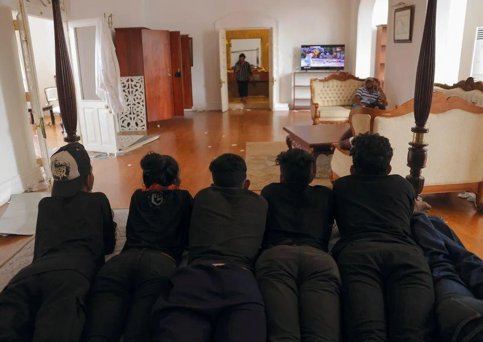 Người biểu tình xem tivi trong phủ tổng thống Sri Lanka ngày 10-7. Ảnh: REUTERS