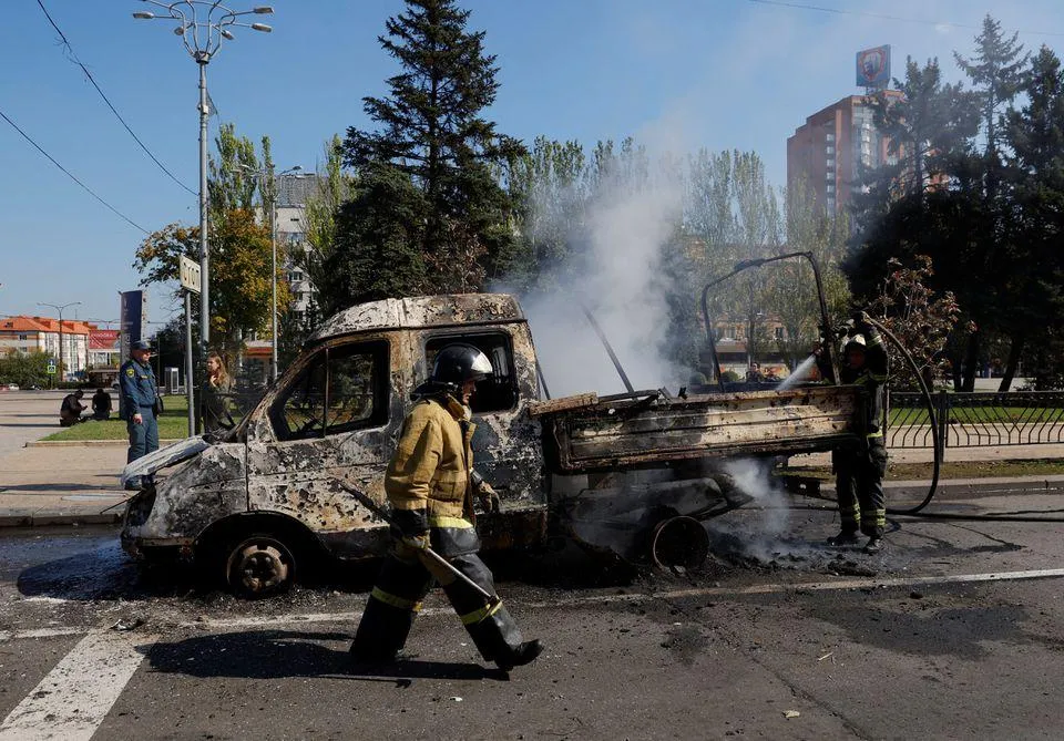 Lính cứu hỏa dập lửa một chiếc xe cháy ở Donetsk do pháo kích hôm 17-9. Ảnh: REUTERS Lính cứu hỏa dập lửa một chiếc xe cháy ở Donetsk do pháo kích hôm 17-9. Ảnh: REUTERS
