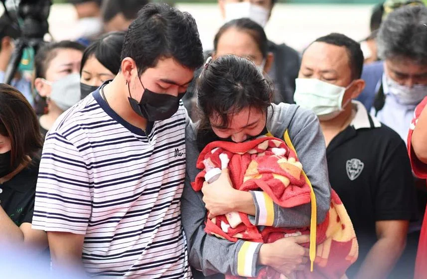 Một người mẹ có con thiệt mạng ôm chiếc chăn và bình sữa của con vào ngày 7-10. Ảnh: AFP