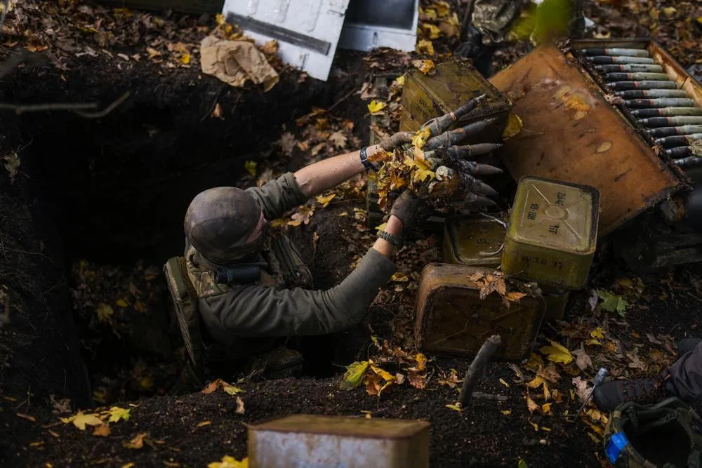 Lính Ukraine ở làng Hrakove, tỉnh Kharkiv (Ukraine) lấy được đạn dược của quân Nga hôm 13-10. Ảnh: AP
