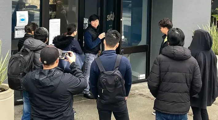 Nhân viên ngân hàng Silicon Valley (trung tâm) nói chuyện với những người đứng bên ngoài chi nhánh ngân hàng này ở TP Santa Clara, bang California (Mỹ) hôm 10-3. Ảnh: AP