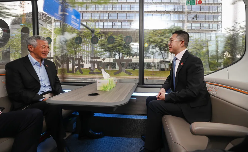 Thủ tướng Lý Hiển Long (trái) ngồi xe buýt tự lái của công ty WeRide. Ảnh: MCI