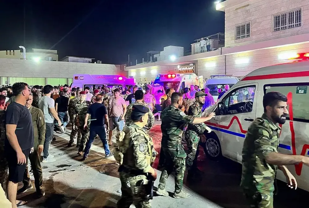 Quân đội và nhân viên cứu hộ làm việc tại hiện trường vụ cháy tiệc cưới tại Iraq hôm 26-9. Ảnh: AFP chay ira.png