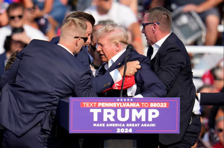 Mật vụ che chắn cho ông Trump. Ảnh: AP trump-chay-mau-tai-noi-tranh-cu.png