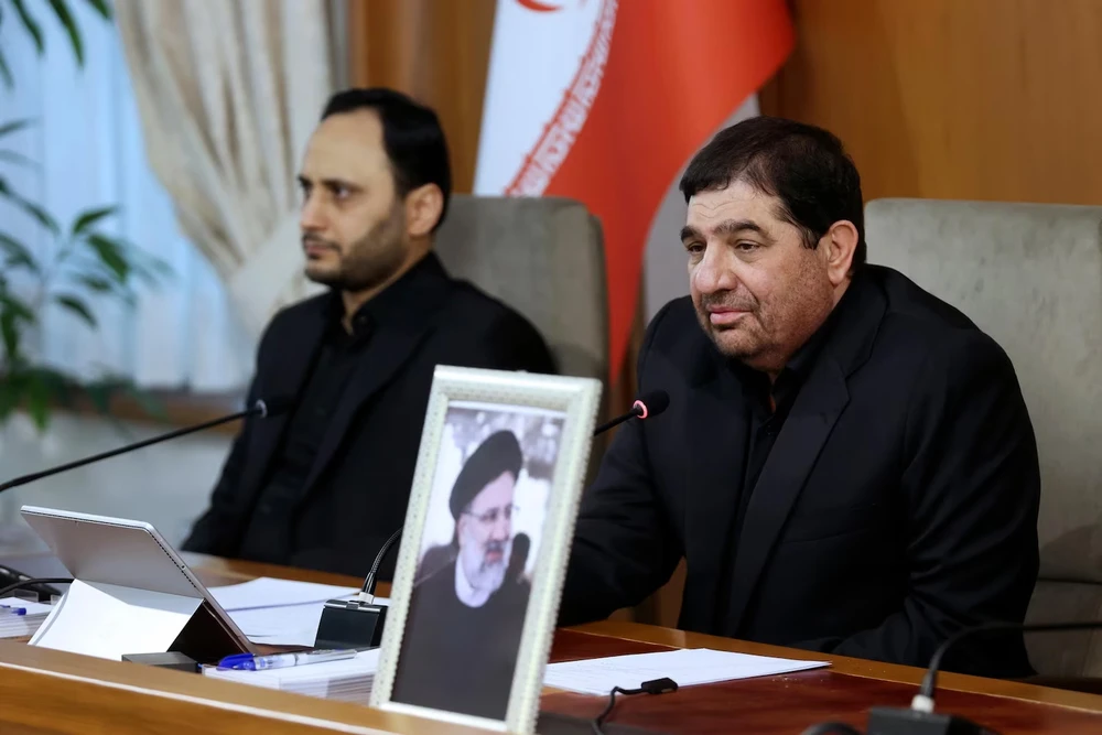 Phó Tổng thống thứ nhất Iran Mohammad Mokhber (phải) dự cuộc họp nội các chính phủ Iran ngày 20-5, bên cạnh là di ảnh của cố Tổng thống Iran - ông Ebrahim Raisi. Ảnh: AP IRAN.jpg