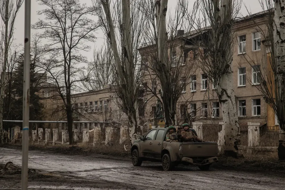 Binh sĩ Ukraine lái xe ngang qua một tòa nhà bị hư hại ở Chasiv Yar do trúng đòn từ các trận giao tranh giữa Moscow và Kiev. Ảnh: GETTY IMAGES Chiến sự Nga-Ukraine