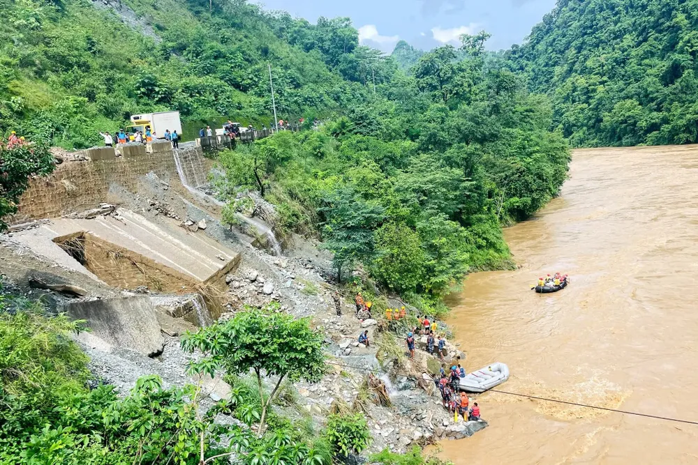 Lực lượng cứu hộ gấp rút tìm kiếm nạn nhân vụ lở đất ở Nepal ngày 12-7. Ảnh: AFP lở đất ở Nepal cuốn 2 xe buýt xuống sông