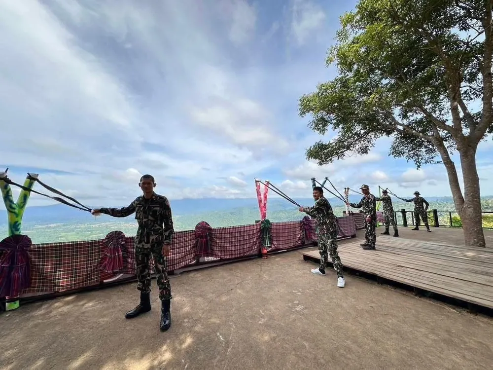 Ảnh Angkor Fresh đăng tải cho thấy hai người mặc đồng phục rằn ri đứng cạnh những ná bắn bi cỡ lớn. Ảnh: ANGKOR FRESH