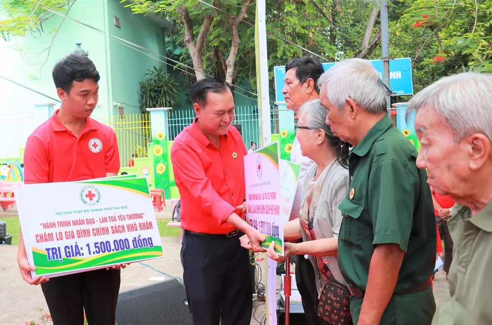 Ông Trần Trường Sơn, Chủ tịch Hội Chữ thập đỏ TP.HCM trao bảng tượng trưng cho gia đình chính sách khó khăn tại TP Thủ Đức. tháng nhân đạo 1.jpg