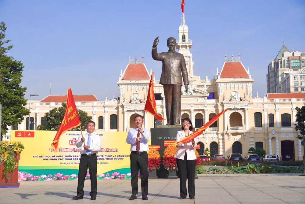 Ông Dương Anh Đức, Trưởng Ban Tuyên giáo và Dân vận Thành ủy TP.HCM (đứng giữa); bà Trần Thị Diệu Thúy, Phó Chủ tịch UBND TP.HCM và ông Nguyễn Tấn Phát, Bí thư Đảng ủy phường Sài Gòn cùng phất cờ khai mạc Tuần lễ hưởng ứng học tập suốt đời năm 2025. Ảnh: HẢI NHI