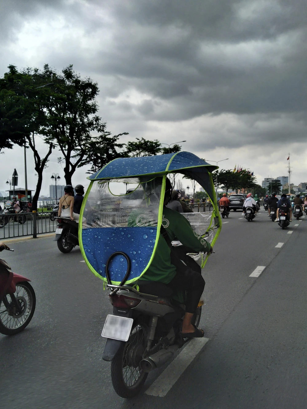 Hiện nay, có một số xe máy dùng tấm nilông làm mui che nắng mưa khi lưu thông trên đường phố. Ảnh: THIÊN THẢO