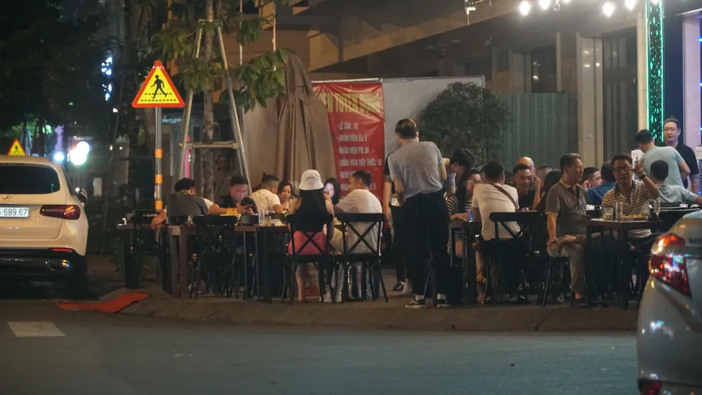 Càng về khuya thì các nhà hàng trên đường số 3 lại càng đông khách và chiếm dụng hết phần vỉa hè làm nơi ăn nhậu. Ảnh: HỮU ĐĂNG