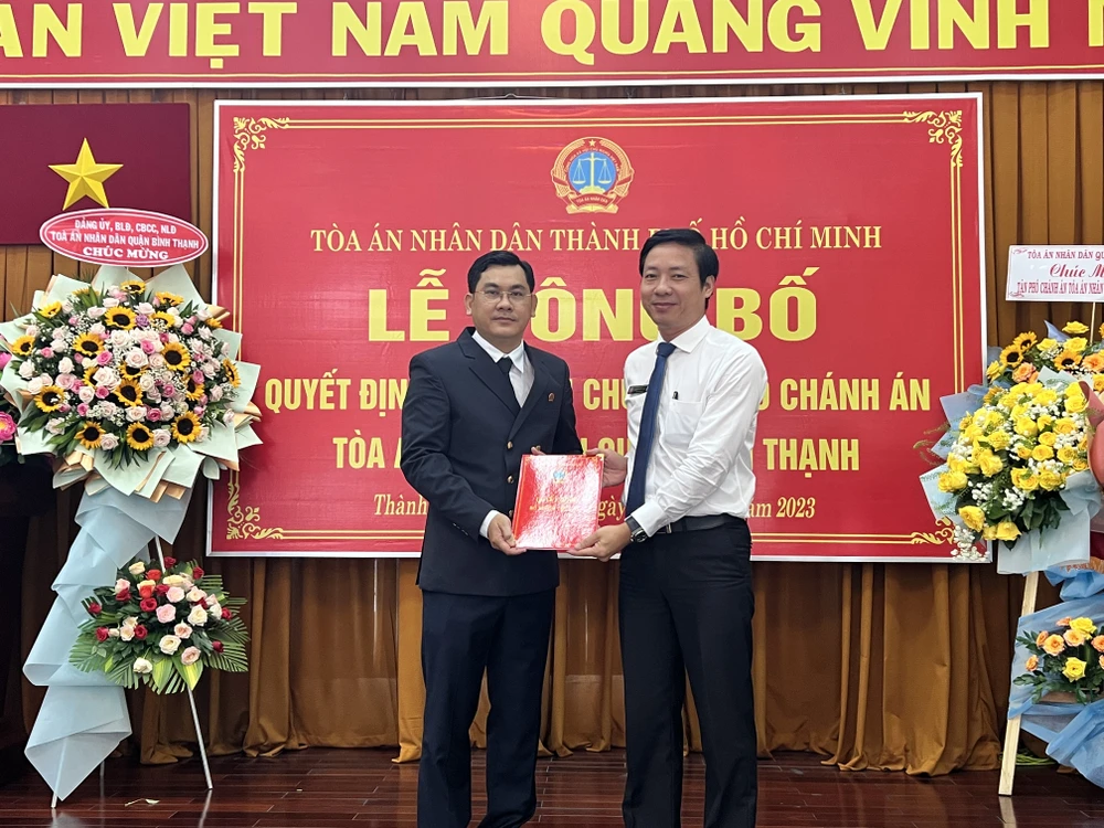 Ông Quách Hữu Thái (áo trắng), Phó Chánh án TAND TP.HCM trao quyết định bổ nhiệm cho ông Lê Thanh Tùng. Ảnh: HỮU ĐĂNG TAND binh thanh.JPG