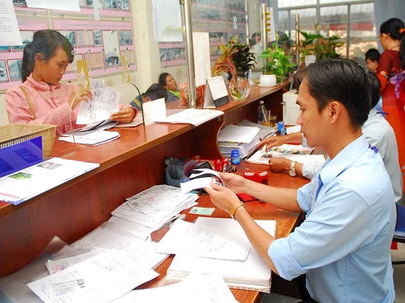 Người dân đang thực hiện thủ tục chứng thực bản sao từ bản chính tại UBND cấp xã. Ảnh: PLO sao y