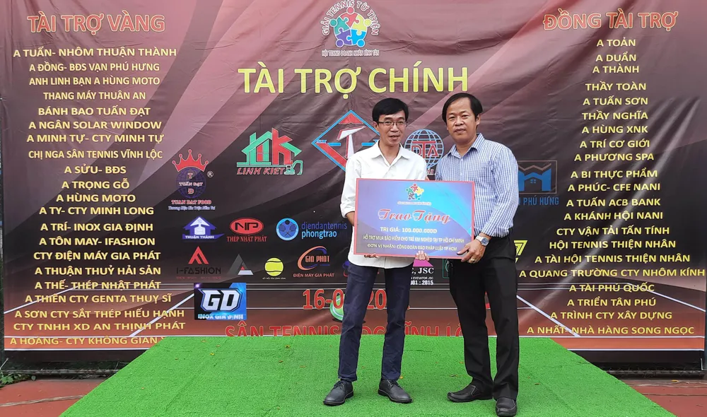 Ông Nguyễn Văn Trường (phải, đại diện ban tổ chức) trao 100 triệu đồng cho đại diện Công đoàn Báo Pháp Luật TP.HCM. Ảnh: TRẦN NGỌC