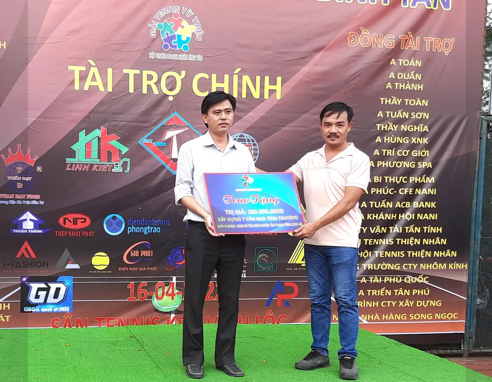 Đại diện UBND xã Tân Ninh, huyện Tân Thạnh, Long An nhận tiền xây nhà tình thương tử ông Nguyễn Văn Dũ (đại diện ban tổ chức). Ảnh: TRẦN NGỌC.