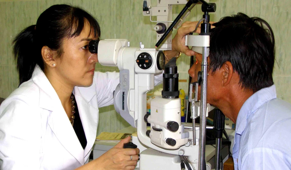 Bác sĩ đang khám mắt cho một bệnh nhân thuộc chính sách. Ảnh: TRẦN NGỌC