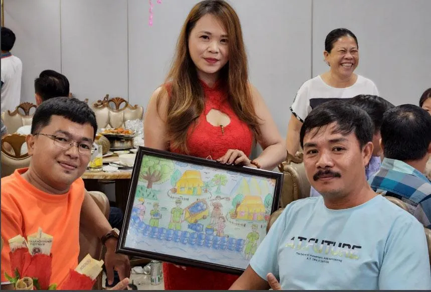 Ông Nguyễn Thanh Dũ (bìa phải) bên bức tranh được mang bán đấu giá. Ảnh: TUẤN ĐẠT