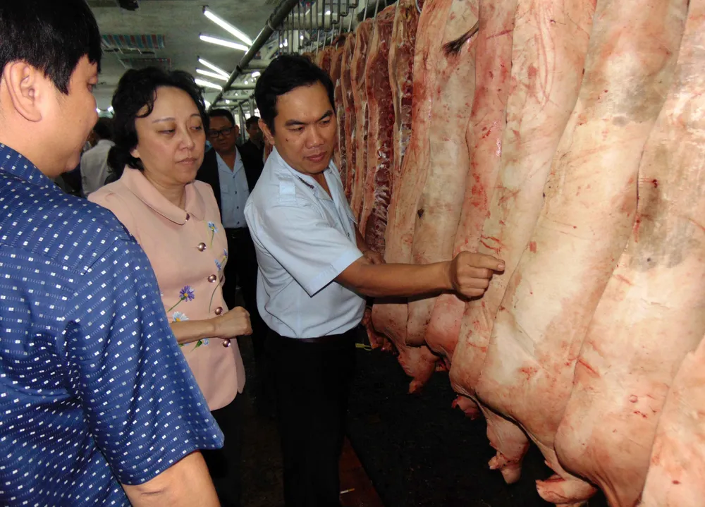 Ban Quản lý an toàn thực phẩm TP.HCM kiểm tra thịt heo kinh doanh tại chợ đầu mối nông sản Hóc Môn. Ảnh: TRẦN NGỌC