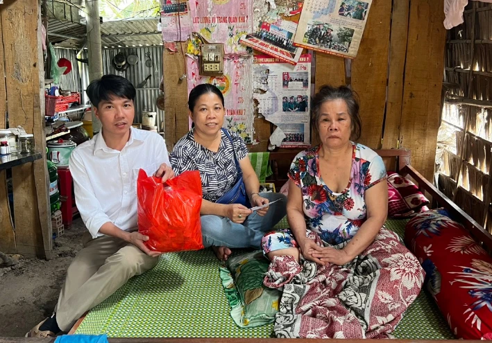 Các thành viên trong đoàn từ thiện tặng quà Tết cho bà Đặng Thị Vân. Ảnh: THANH NAM