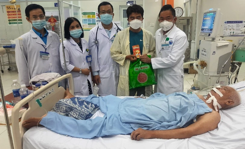 Lãnh đạo BV huyện Bình Chánh tặng quà Tết cho bệnh nhân điều trị nội trú trong đêm giao thừa. Ảnh: PHƯỚC LỢI