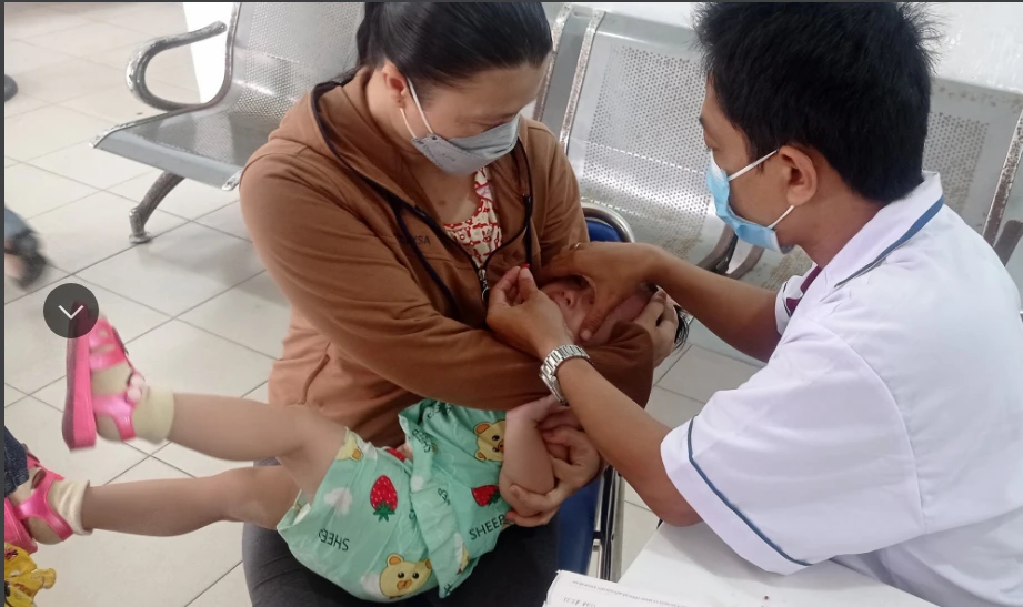 Nhân viên y tế huyện Hóc Môn, TP.HCM cho trẻ uống vitamin A. Ảnh: TRẦN NGỌC Nhân viên y tế huyện Hóc Môn, TP.HCM cho trẻ uống vitamin A. Ảnh: TRẦN NGỌC