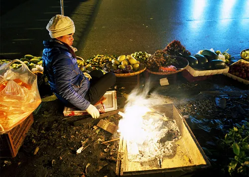 Nhiệt độ xuống thấp về đêm, nhiều người buôn bán phải đốt lửa sưởi ấm. ẢNh: Nguyên Anh.