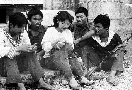Bộ ảnh vô giá về cuộc sống và chiến đấu ở Trường Sa năm 1988 ảnh 21 Ca sĩ Thanh Thanh vừa hát, vừa tranh thủ khâu áo cho anh em lính đảo.