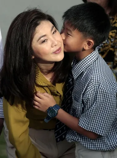 Supasek hôn lên má chúc mừng sinh nhật lần thứ 44 của mẹ. Ảnh: Reuters. Supasek Amornchat kisses his mother Yingluck Shinawatra during her birthday at their house in Bangkok June 21, 2011. Yingluck Shinawatra is the sister of toppled former Thai premier Thaksin Shinawatra and the prime ministerial candidate for the country's biggest opposition Puea Thai party. REUTERS