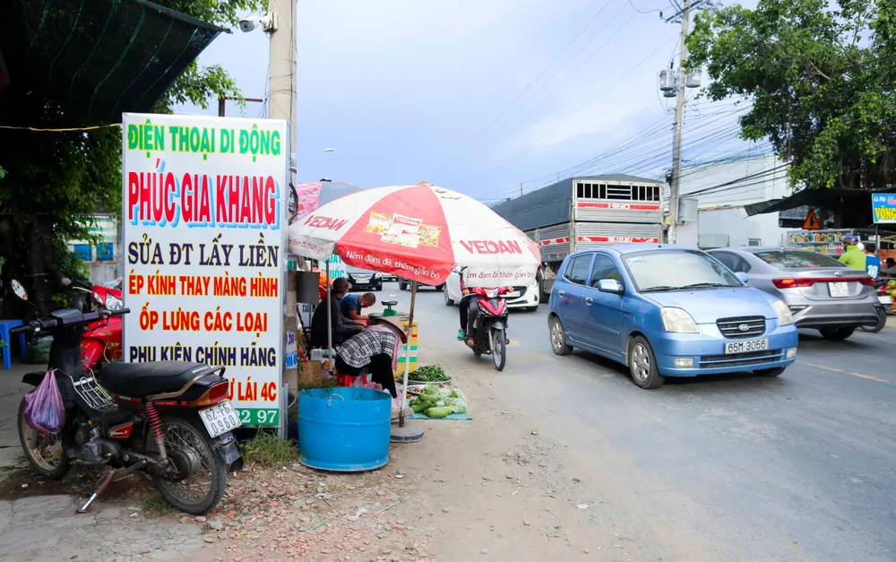 Người bán hàng lấn chiếm xuống lòng đường tiềm ẩn nguy cơ tai nạn giao thông.