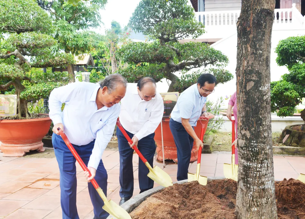 Chủ tịch nước Nguyễn Xuân Phúc trồng cây lưu niệm tại khu lưu niệm đồng chí Trương Văn Bang. Ảnh: Thành Phát.