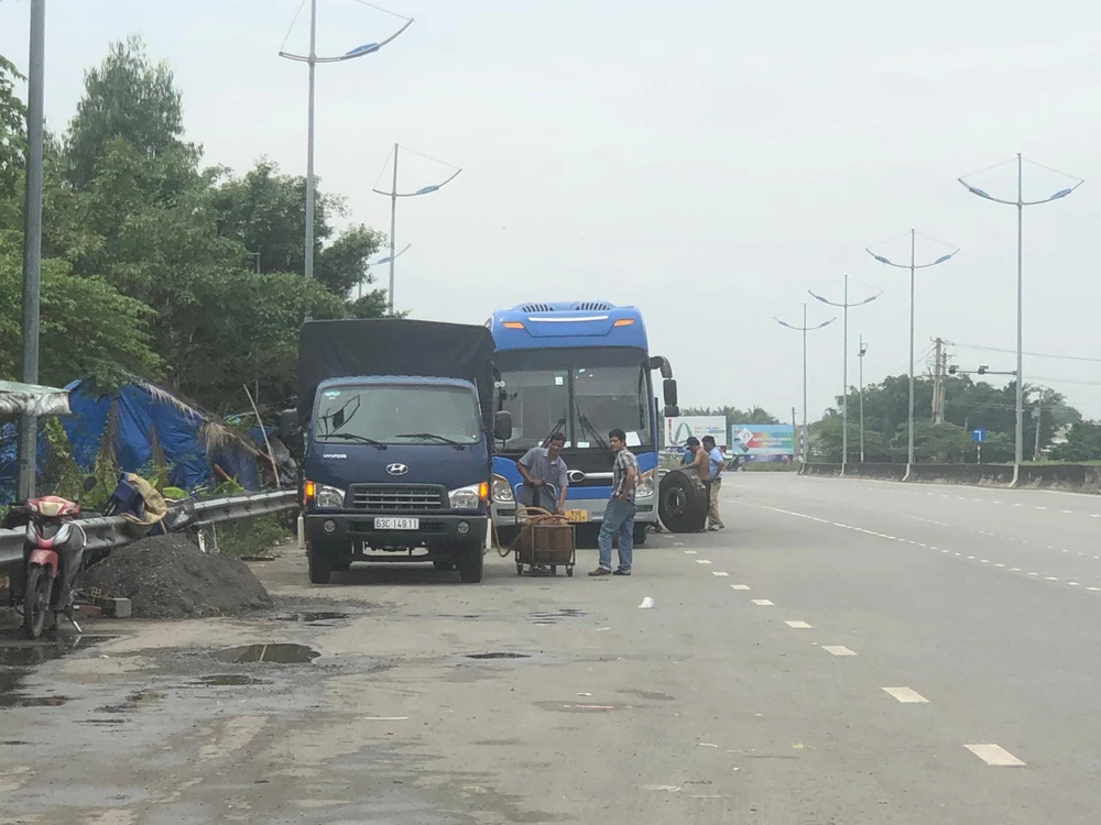 Nhiều phương tiện dừng lại trên đường dẫn cao tốc để sửa chữa. Ảnh: HUỲNH DU