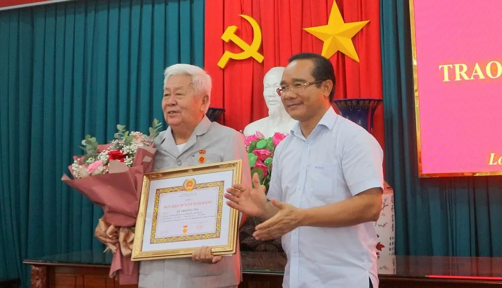 Bí thư Tỉnh ủy - Nguyễn Văn Được trao Huy hiệu 55 năm tuổi Đảng cho ông Lê Thanh Long. Ảnh: CTV