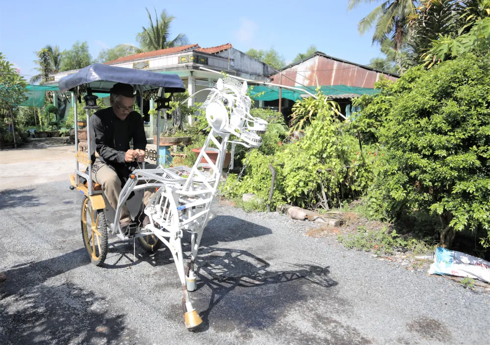 Ông Đức thường mặc lên bộ trang phục áo dài khăn đóng, cởi trên con ngựa sắt do mình chế tạo biểu diễn trên đường quê. Ảnh: HUỲNH DU