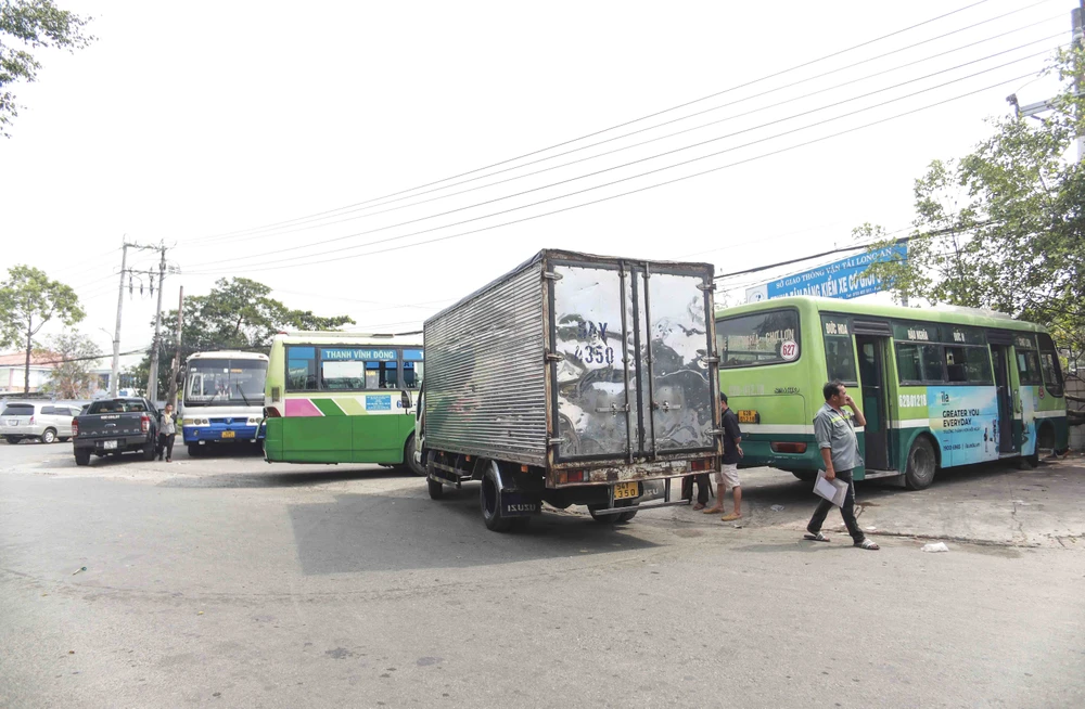 Ô tô tải, ô tô khách đậu đặt kín lối vào Trung tâm Đăng kiểm xe cơ giới 62.01S. Ảnh: HUỲNH DU