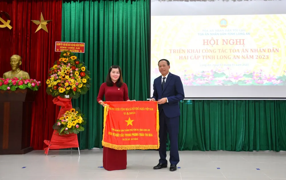 Phó Chánh án Thường trực TAND Tối cao – Nguyễn Trí Tuệ tặng Cờ thi đua của Chính phủ cho tập thể TAND TP Tân An. Ảnh: CTV