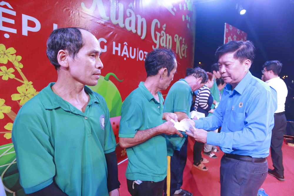 Chủ tịch Liên đoàn Lao động tỉnh - Nguyễn Văn Quí tặng quà cho công nhân, lao động. Ảnh: HUỲNH DU