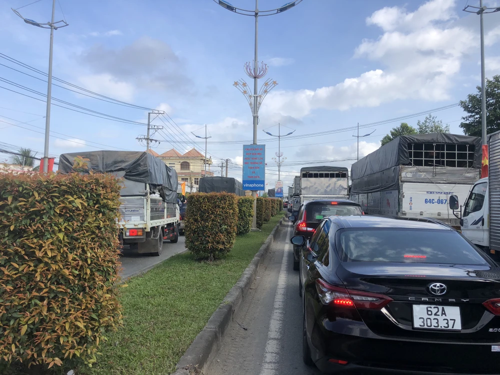 Nhiều xe đã lấn sang làn đường ngược chiều để chạy trên quốc lộ 62. Ảnh: HUỲNH DU